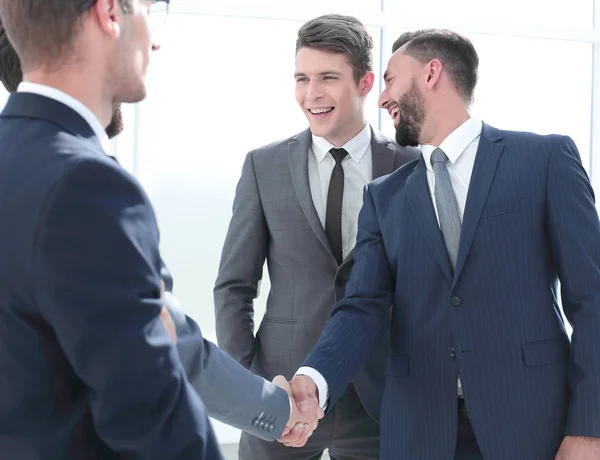 Усміхнений бізнесмен тремтить руками зі своїм партнером — стокове фото
