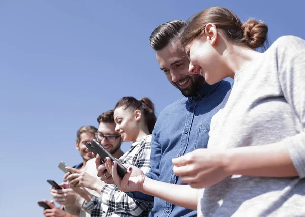 Jóvenes que utilizan teléfonos inteligentes para buscar en la red — Foto de Stock