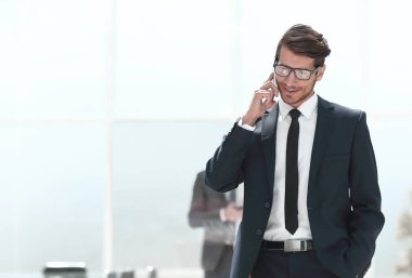 Kendine güvenen iş adamı cep telefonuyla konuşuyor..