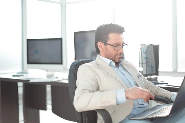 Homme d'affaires utilisant un ordinateur portable assis à son bureau — Photo