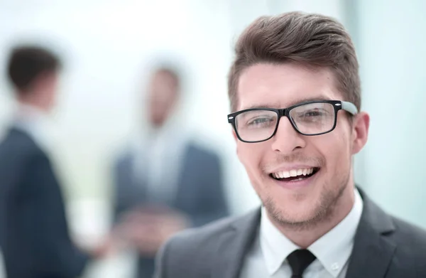 Κλείστε up.smiling νεαρός επιχειρηματίας στο παρασκήνιο γραφείο — Φωτογραφία Αρχείου