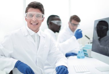 modern bilim adamı bir bilgisayar monito önünde oturan