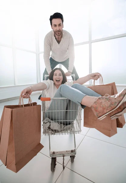 आदमी अपनी प्रेमिका को एक शॉपिंग कार्ट में ले जाता है — स्टॉक फ़ोटो, इमेज