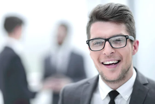 Cerrar up.smiling joven empresario en el fondo de la oficina — Foto de Stock