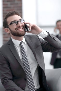 Modern bir binada telefonda konuşan çekici bir işadamı.