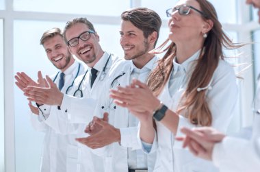 Bir grup başarılı doktor alkışlıyor.