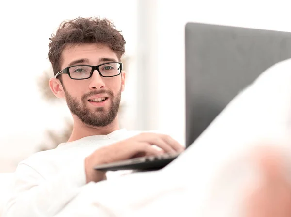 Lächelnder Mann mit Laptop auf Bett liegend — Stockfoto