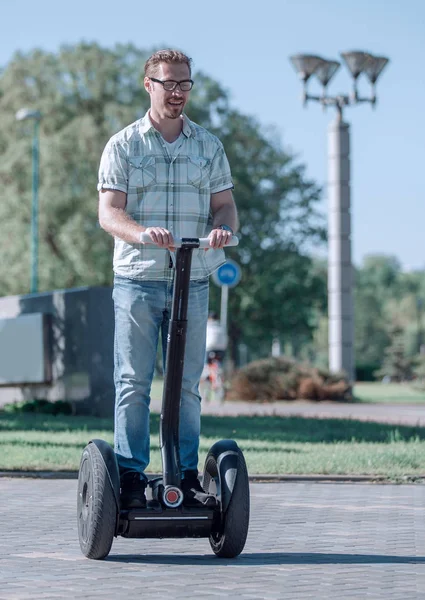 Heureux homme moderne chevauchant un mini hoverboard dans le parc — Photo