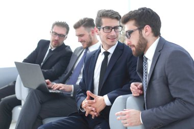 Grup ofis bekleme odasında oturup iş adamları