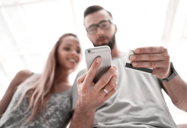 Jovem casal usando um smartphone para comprar na loja online — Fotografia de Stock