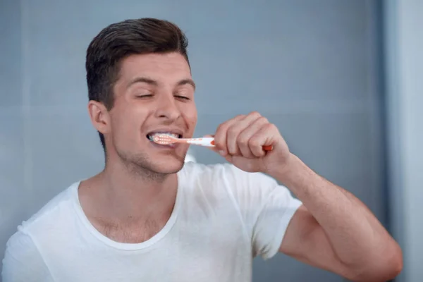 young man brushing his teeth in the bathroom