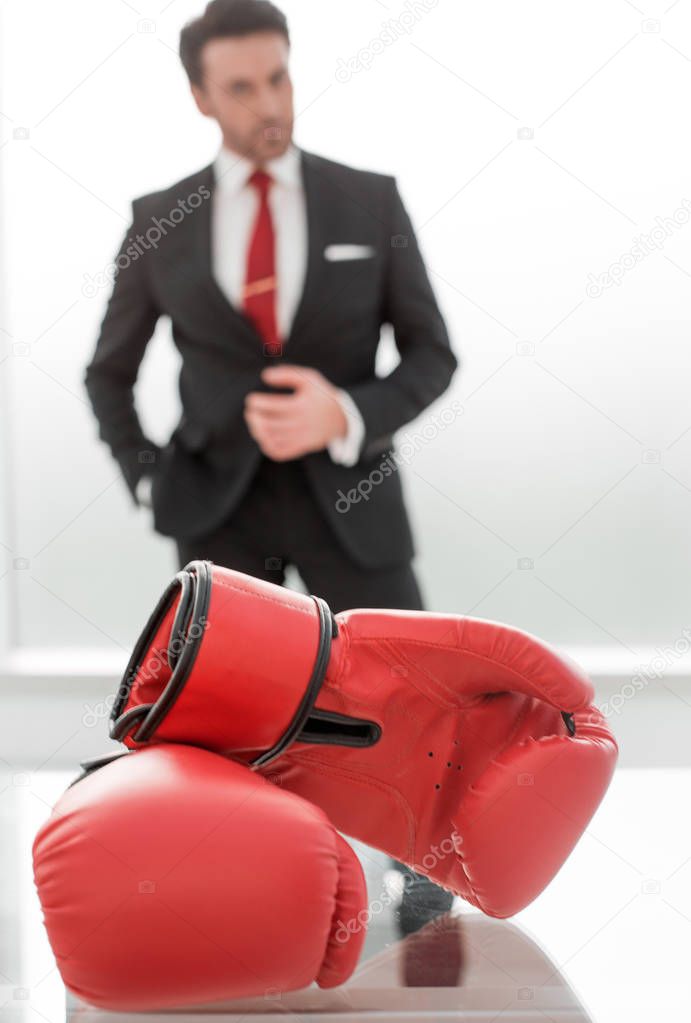 Boxing gloves on the businessmans desktop