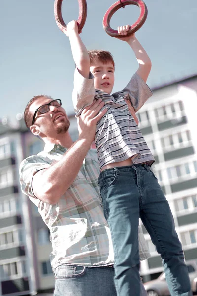 Far hjälper till sin son att komma ikapp på baren — Stockfoto