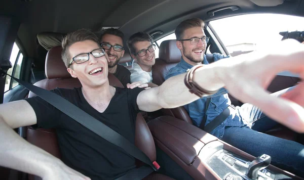 Närbild. en grupp vänner peka på vägen medan du sitter i bilen — Stockfoto