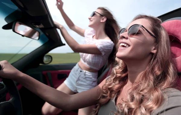 Stäng up.cheerful unga kvinnor reser i en cabriolet — Stockfoto