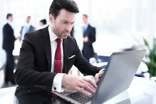 Empresário digitando em um laptop, sentado em sua mesa — Fotografia de Stock