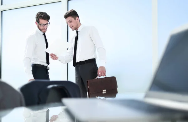 Two young people in the office are standing by the window — Stock Photo, Image