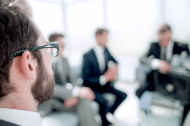 yakın çekim. seyirciler ofis lobisinde bakarak işadamı