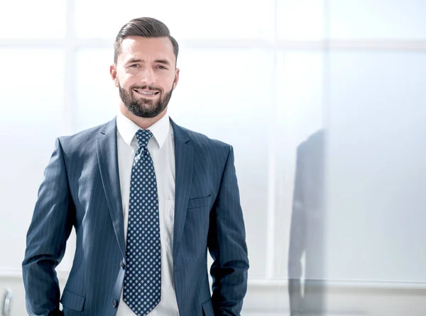 Portrait of a businessman on the background of an office window — Stock Photo, Image