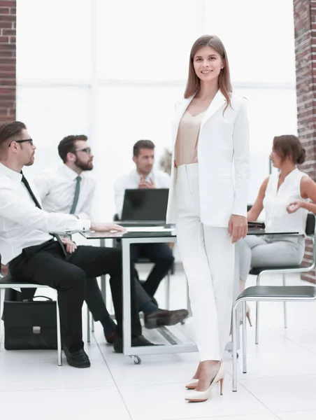 Junge Geschäftsfrau steht neben dem Schreibtisch — Stockfoto