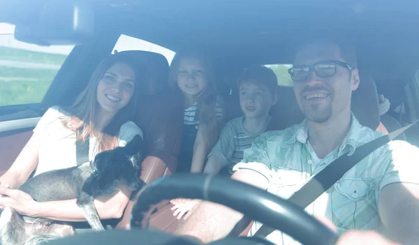 family with two children traveling in a family car