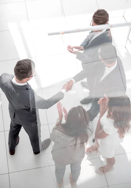 Handshake parceiros de negócios atrás da porta de vidro — Fotografia de Stock