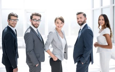 Arka manzara. İş ekibi gülümsüyor ve kameraya bakıyor.