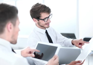 Takım iki İşadamlarından tablet ve dokuments ofiste kullanarak yeni proje tartışıyor.