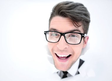 Genç işadamı kağıttan bir duvarı yıkıyor.