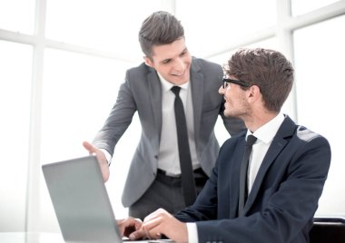 dizüstü bilgisayar ekranına bakarak gülümseyen iş arkadaşları