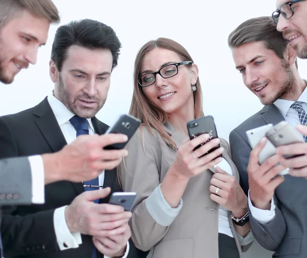 Group of business people reading a message on phones — Stock Photo, Image