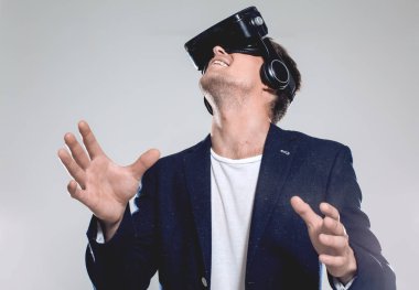 Gri arka planda duran havalı iş adamı