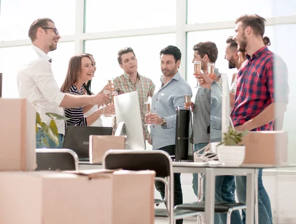 Бизнес-команда празднует переезд стоя в офисе — стоковое фото