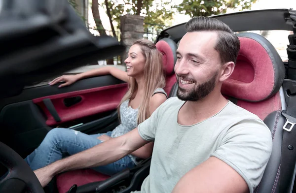 successful man sitting behind the wheel of a luxury car