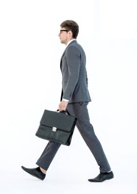 yan görünümü. ileri bir işadamı bir deri evrak çantası ile gelir.