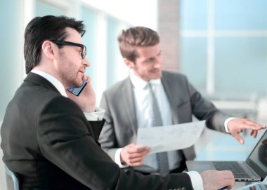 çalışanların yeni veriyi denetlemek için bir dizüstü bilgisayar kullanmak.