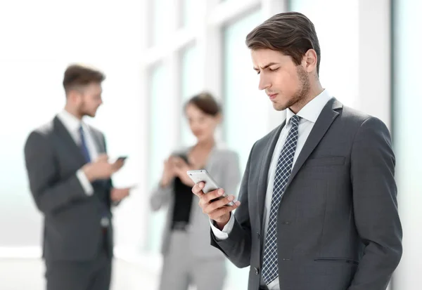 Hombre de negocios serio leyendo SMS en su teléfono inteligente . — Foto de Stock