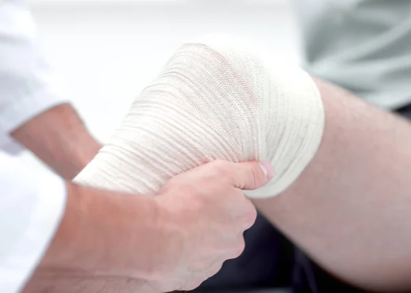 Closeup. doctor bandaging a patients leg — Stock Photo, Image