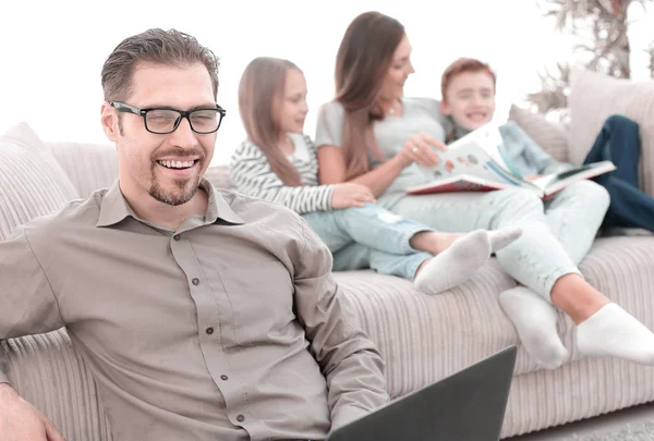 Glimlachende man met een laptop in zijn appartement. — Stockfoto