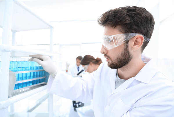 side view of focused scientist holding test tube in laboratory