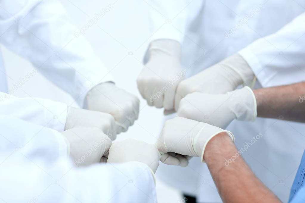 Doctors and nurses coordinate hands.