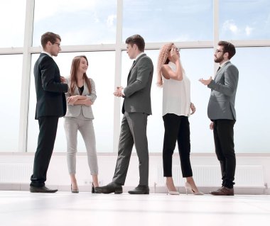 Grup geniş bir salonda ayakta iş adamları