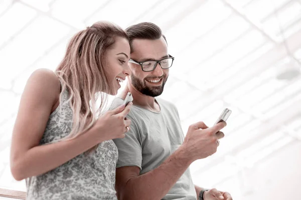 Riendo pareja viendo fotos en el teléfono inteligente — Foto de Stock