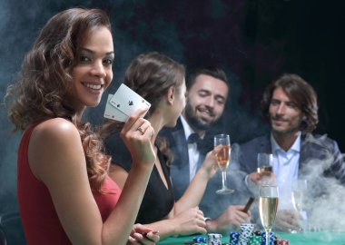 siyah arka plan üzerine poker oynamaya genç esmer kadın