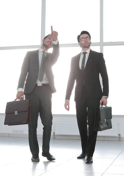 Far away. two businessmen are walking in the lobby of the office — Stock Photo, Image