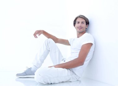 Beyaz bir duvar oturan endişeli adam