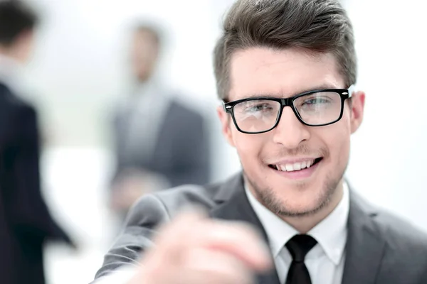 Close up.careful joven hombre de negocios en un fondo borroso . — Foto de Stock