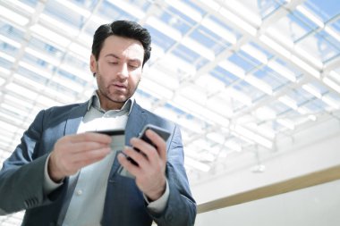 Kapat. İş adamı akıllı telefondan numarayı arıyor.
