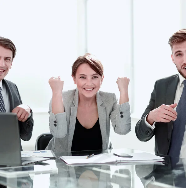 Счастливая деловая команда, сидящая за рабочим столом — стоковое фото