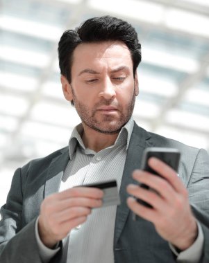 Kapat. İş adamı akıllı telefondan numarayı arıyor.
